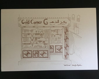 Può includere: Un disegno in bianco e nero di una vetrina con un cartello che recita "Gold Corner" in inglese e arabo. La vetrina è piena di gioielli, tra cui collane, orecchini e braccialetti. Il disegno è firmato "Gold Corner - Jennifer Heyden."