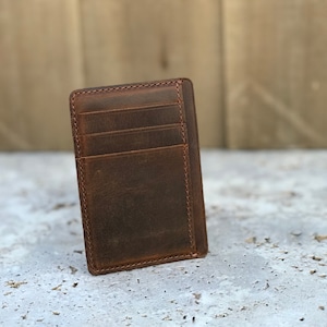 May include: A brown leather wallet with multiple card slots. The wallet has a distressed look and is made of high-quality leather.