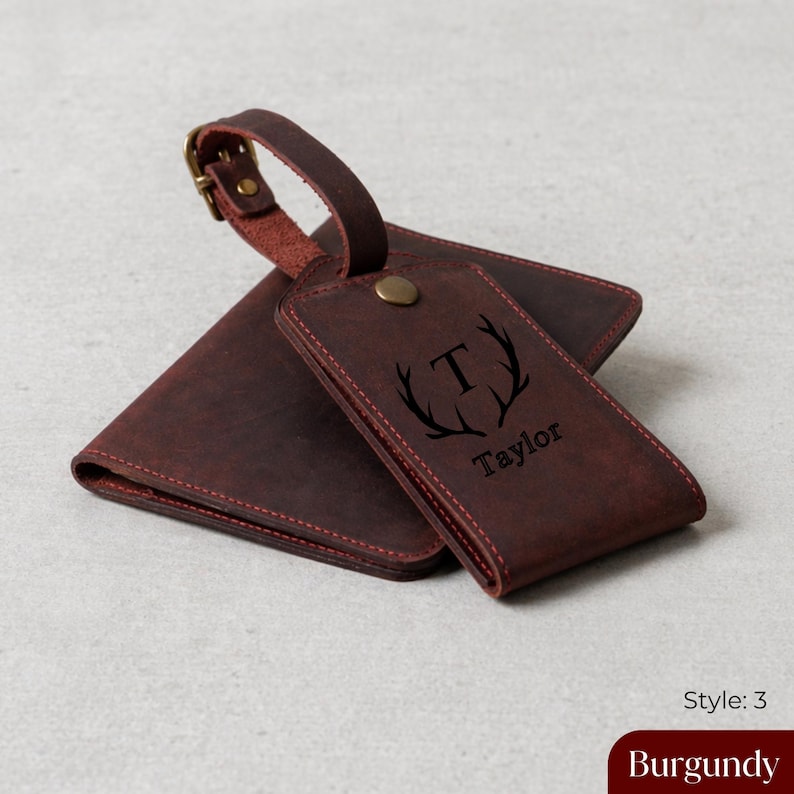 Puede incluir: Juego de etiqueta de equipaje y cartera de cuero burdeos. La etiqueta presenta un monograma con la letra "T" y el nombre "Taylor". La cartera y la etiqueta son de color burdeos oscuro con costuras rojas.