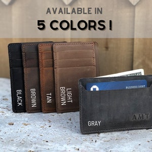 May include: Five leather card holders in different colours: black, brown, tan, light brown, and grey. The grey card holder has a business debit card and cash inside. The text "AVAILABLE IN 5 COLORS!" is at the top of the image.