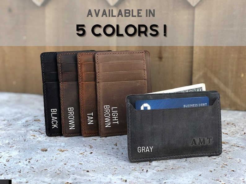 May include: Five leather card holders in different colours: black, brown, tan, light brown, and grey. The grey card holder has a business debit card and cash inside. The text "AVAILABLE IN 5 COLORS!" is at the top of the image.