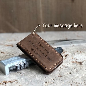 May include: Brown leather money clip with a stitched edge and engraved text: "I love you to the moon and back &hearts; Lauren".