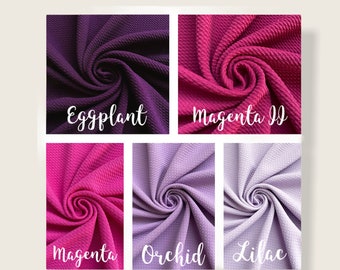 May include: Six fabric swatches in different shades of purple and pink. The swatches are arranged in a grid with the names "Eggplant", "Magenta II", "Magenta", "Orchid", and "Lilac" written below each swatch.