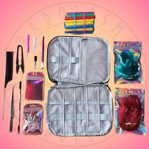 May include: A doll rerooting kit labeled KYRADOLLSMITH'S REROOTING KIT, featuring a black zippered organizer case, a black comb, metal tweezers, a needle tool, a purple stylus, and two iridescent pouches containing teal and red hair fibers.