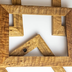 Può includere: Quattro cornici per foto in legno rustico disposte in un motivo geometrico, creando un design unico e moderno. Le cornici sono in legno naturale con una finitura marrone caldo e hanno un aspetto invecchiato.