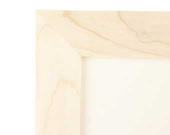 Könnte beinhalten: Nahaufnahme der Ecke eines Bilderrahmens aus Naturholz. Der Rahmen besteht aus unbehandeltem, hellem Holz mit einer glatten Oberfläche.