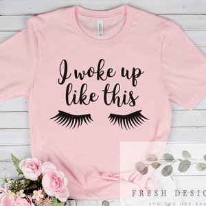 May include: Pink t-shirt with the text "I woke up like this" and a pair of eyelashes printed on it.