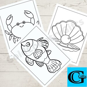 May include: Three black and white colouring pages featuring a crab, a fish, and a pearl inside a clam shell. The pages are on a white wooden background.