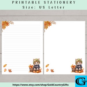 May include: Printable stationery featuring a cute orange tabby kitten wearing a green hat and blue jacket, holding a basket of apples and pumpkins. The background is a watercolour illustration of autumn leaves in shades of orange, yellow, and brown. The text "https://www.etsy.com/shop/GoldCountryGifts" is at the bottom of the page.