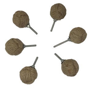 Może przedstawiać: Sześć brązowych gałek do szafek z liną i srebrnymi śrubami. Lina jest zawiązana w supeł, a gałki są okrągłe.