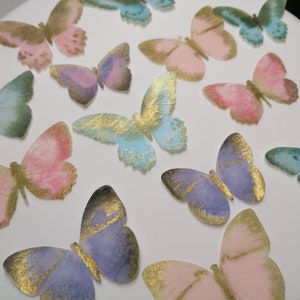 Pre-cut edible wafer butterflies.  Cake/cupcake decorations. Purple, blue, pink and white with gold accent. butterfly cake topper