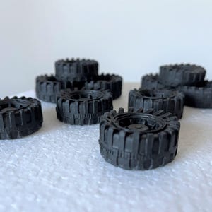 A collection of black rubber tires arranged on a white surface.