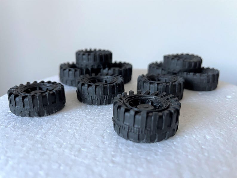 A collection of black rubber tires arranged on a white surface.