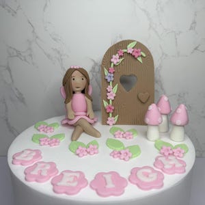 Set di decorazioni per torte a forma di fata personalizzate. Giardino commestibile per decorazioni di torte di compleanno. Porta delle fate in pasta di zucchero, funghi e fiori. Torta per feste a tema bambina.