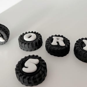 a collection of black and white tire-shaped objects, with the word "RORY" spelled out using the tires.