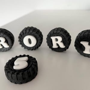 a collection of black tire-shaped objects with white lettering spelling out the word "RORY".