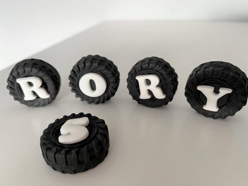 a collection of black tire-shaped objects with white lettering spelling out the word "RORY".