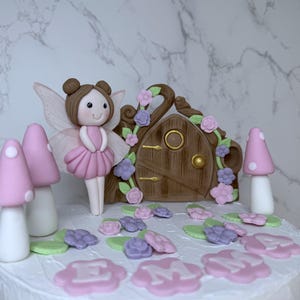 Decorazioni per torte di compleanno a tema giardino fatato. Decorazioni per bambine. Porta delle fate in pasta di zucchero, funghi e fiori. Torta a tema floreale.