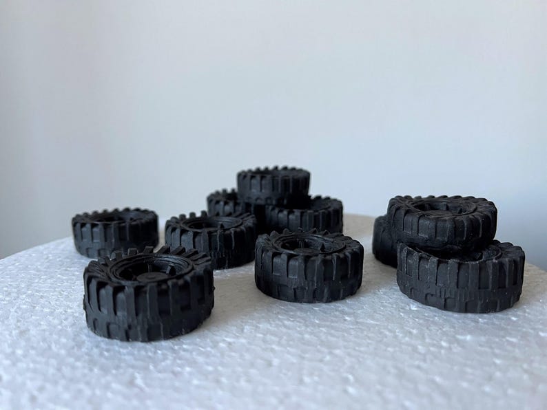 A collection of black rubber tires arranged on a white surface.
