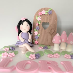 Decorazioni personalizzate per torte di compleanno a tema giardino delle fate. Decorazioni per bambine. Porta delle fate in pasta di zucchero, funghi e fiori. Torta a tema floreale.