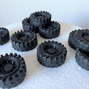 A collection of black rubber tires arranged on a white surface.