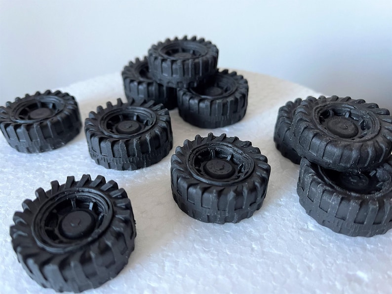 A collection of black rubber tires arranged on a white surface.