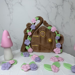 Decorazioni per torte di compleanno a tema giardino fatato. Decorazioni per bambine. Porta delle fate in pasta di zucchero, funghi e margherite. Torta a tema floreale.