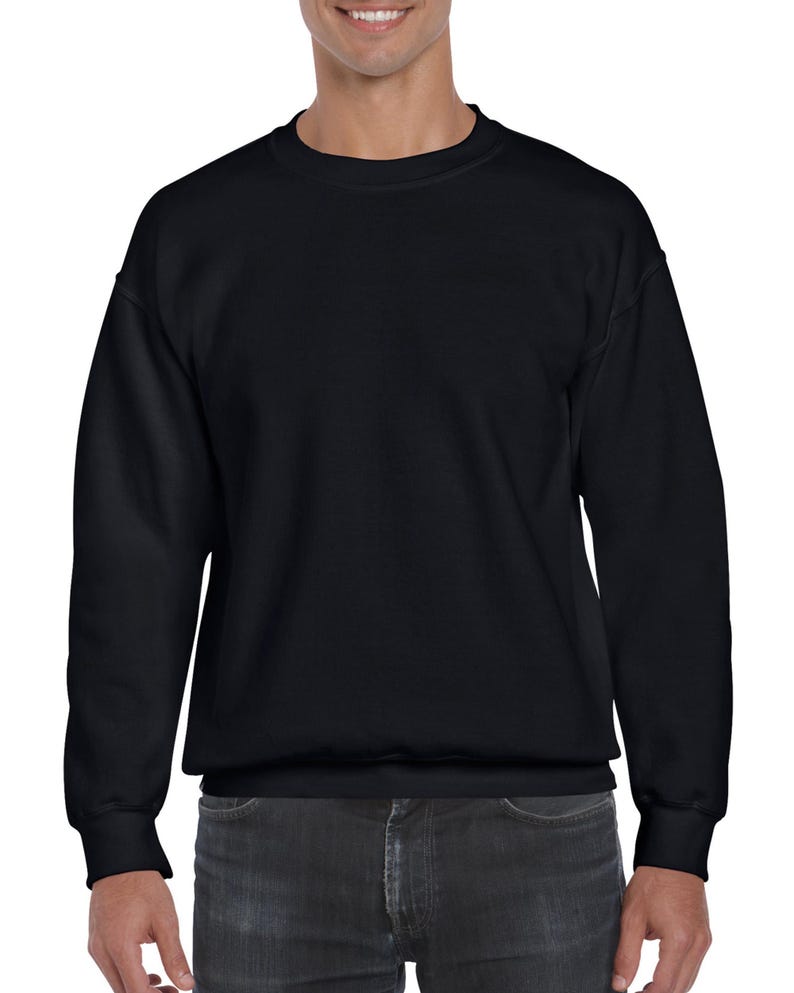May include: A solid black crew neck sweatshirt. The long-sleeved top has a ribbed hem and cuffs. The sweatshirt is made of a soft material and is suitable for casual wear. The model is wearing dark gray jeans.