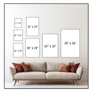 May include: A diagram showing different sizes of picture frames, with measurements in inches, displayed on a white wall above a beige couch with red throw pillows.