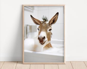May include: A framed print showing a donkey enjoying a bubble bath. The donkey has brown and white fur, wet hair, and large ears. The bathroom is white, and the print is in a light wood frame.