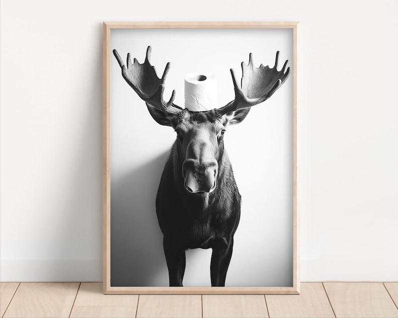 May include: A black and white photograph of a moose wearing a toilet paper roll on its head.