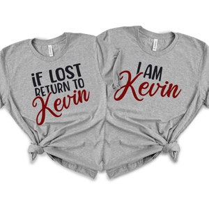 May include: Two gray t-shirts with a matching design. One shirt says "if lost return to Kevin" in black and red lettering. The other shirt says "I am Kevin" in black and red lettering.