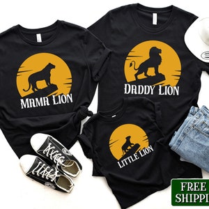 May include: A set of three black t-shirts with a lion silhouette and a yellow sun graphic. The shirts read "Mama Lion", "Daddy Lion", and "Little Lion".