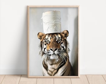 May include: A framed print featuring a tiger wearing a toilet paper roll as a hat. The tiger has a brown and black striped coat, with a focused gaze. The background is a light gray, and the frame is a light wood color.
