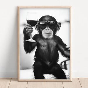 May include: A black and white photo of a chimpanzee wearing sunglasses and holding a glass of red wine.