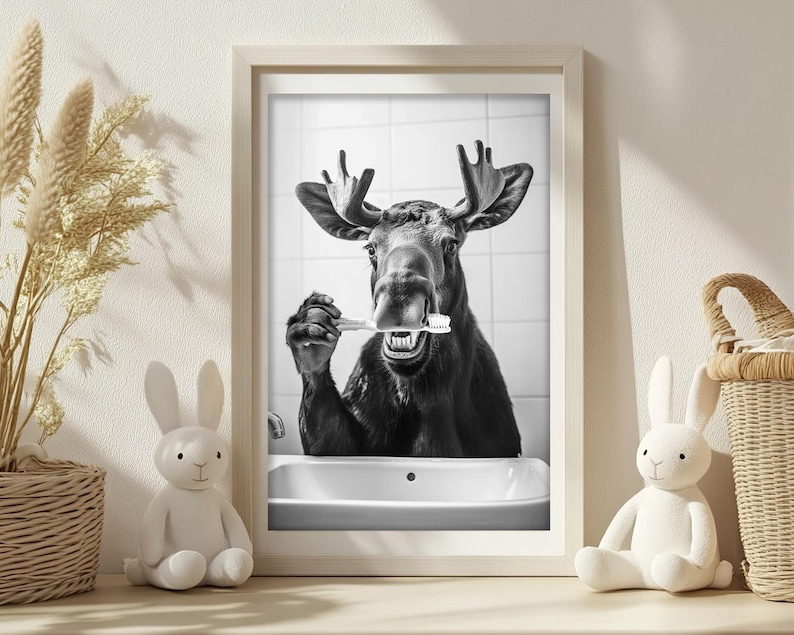 May include: A black and white photo of a moose with its mouth open, holding a toothbrush in its mouth. The moose is in a bathroom setting with a white sink and tiled walls.