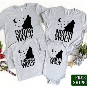 Pode incluir: Um conjunto de quatro t-shirts cinzas com silhuetas de lobos e o texto "Daddy Wolf", "Mama Wolf", "Brother Wolf" e "Sister Wolf".