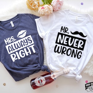 May include: Two t-shirts with a couple's theme. The blue shirt says "Mrs. Always Right" with a white lip print. The white shirt says "Mr. Never Wrong" with a black mustache.