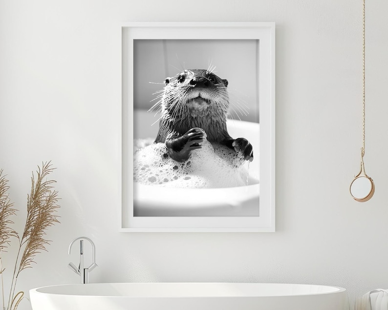 May include: A black and white photo of an otter in a bathtub full of bubbles. The otter is looking up at the camera with its paws on the edge of the tub.