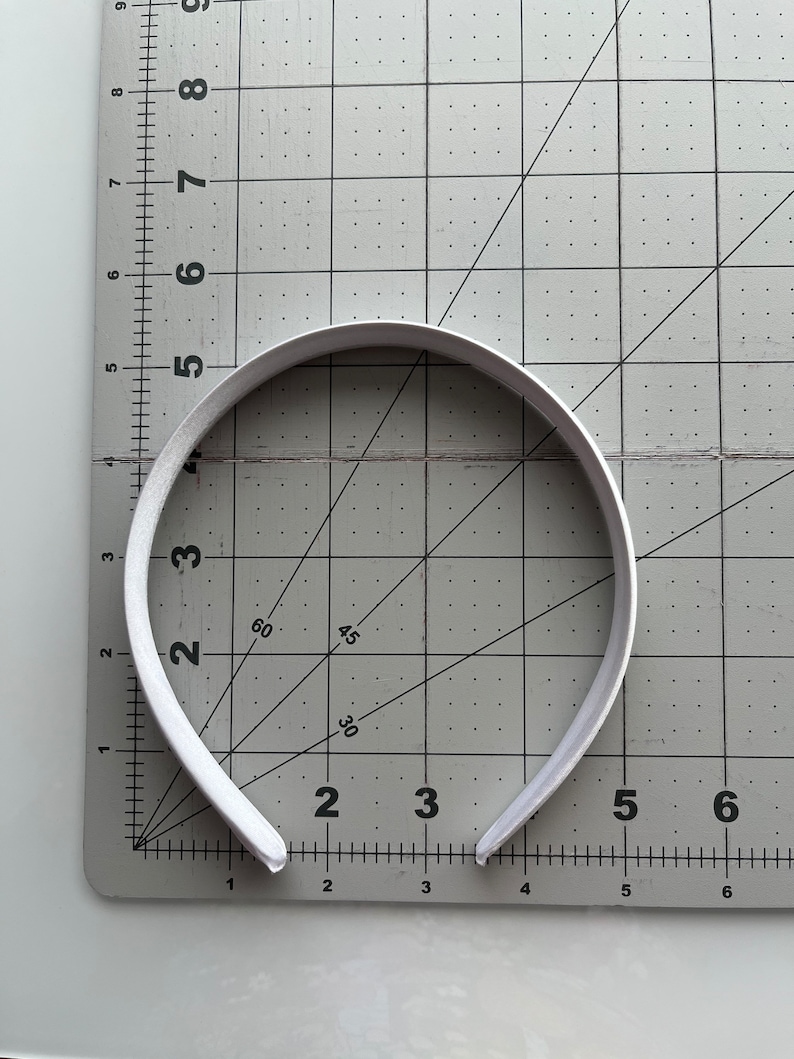 May include: A white headband measuring approximately 5 inches in diameter.