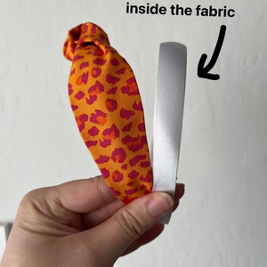 May include: A headband with a leopard print fabric covering a silver headband. The text "This is the headband inside the fabric" is visible in the image.
