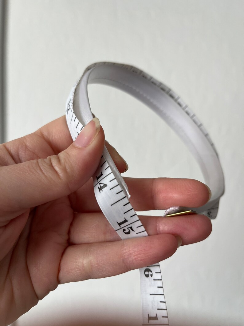 May include: White measuring tape with black markings, showing numbers 13, 14, 15, and 16.
