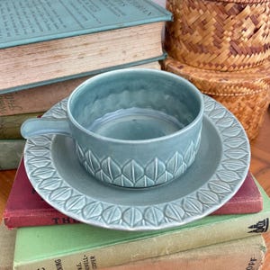 May include: A set of three ceramic mugs with a speckled, matte finish. The mugs are in shades of cream, light gray, and dark gray. Each mug has a simple, minimalist design, perfect for coffee or tea.