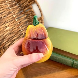 Peut inclure: Ensemble de trois mugs en céramique avec une finition mate et mouchetée. Les tasses sont grises, blanches et noires. Chaque mug a un design simple et moderne, idéal pour le café ou le thé. Les tasses sont empilées.