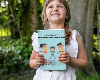 May include: A young person holds a light blue book titled "Journey Joy" with the tagline "non-stop fun from start to finish." The cover features cartoon children jumping. The background is a natural outdoor setting with trees.