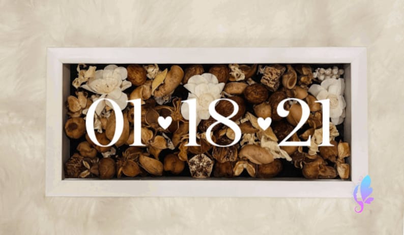 May include: A white frame filled with potpourri and the date "01.18.21" written in white.