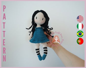 May include: Crocheted doll with long black hair, wearing a blue dress and black and white striped stockings. The doll is being held by a hand.