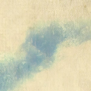 May include: A textured, off-white surface featuring a prominent, diagonal wash of muted blue pigment. The blue color appears blended and soft, creating a gradient effect across the cream-colored background, which has a visible, slightly grainy texture.