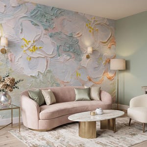 K&ouml;nnte beinhalten: Ein Wohnzimmer mit einem gro&szlig;en Wandbild mit dicken, strukturierten Impasto-Pinselstrichen in Pastellt&ouml;nen wie Wei&szlig;, Rosa, Gelb und Salbeigr&uuml;n. Ein geschwungenes rosa Sofa, ein wei&szlig;er Sessel und ein ovaler Marmor-Couchtisch mit Goldfu&szlig;.