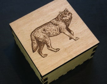 May include: A wooden box with a laser-engraved image of a wolf on the lid. The box is made of light wood with a dark brown stain.